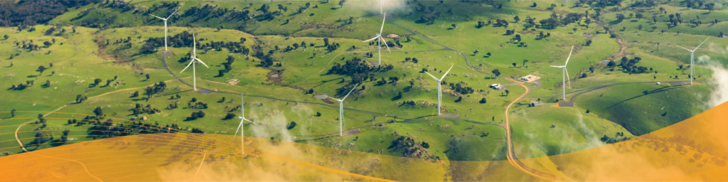 Aerial view of a wind farm with multiple wind turbines spread across rolling green hills, connected by winding access roads, with light clouds drifting across the landscape and a translucent orange graphic overlay along the bottom of the image.